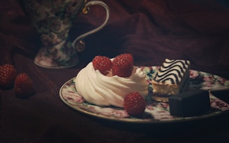 An inviting display of tea cakes with icing and fresh fruit toppings on a white plate.