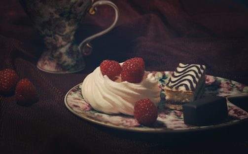 An inviting display of tea cakes with icing and fresh fruit toppings on a white plate.