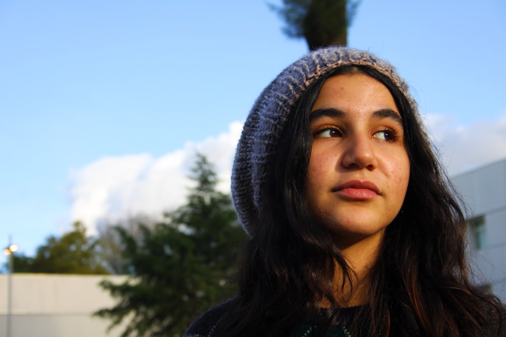 a woman with long hair wearing a knitted hat