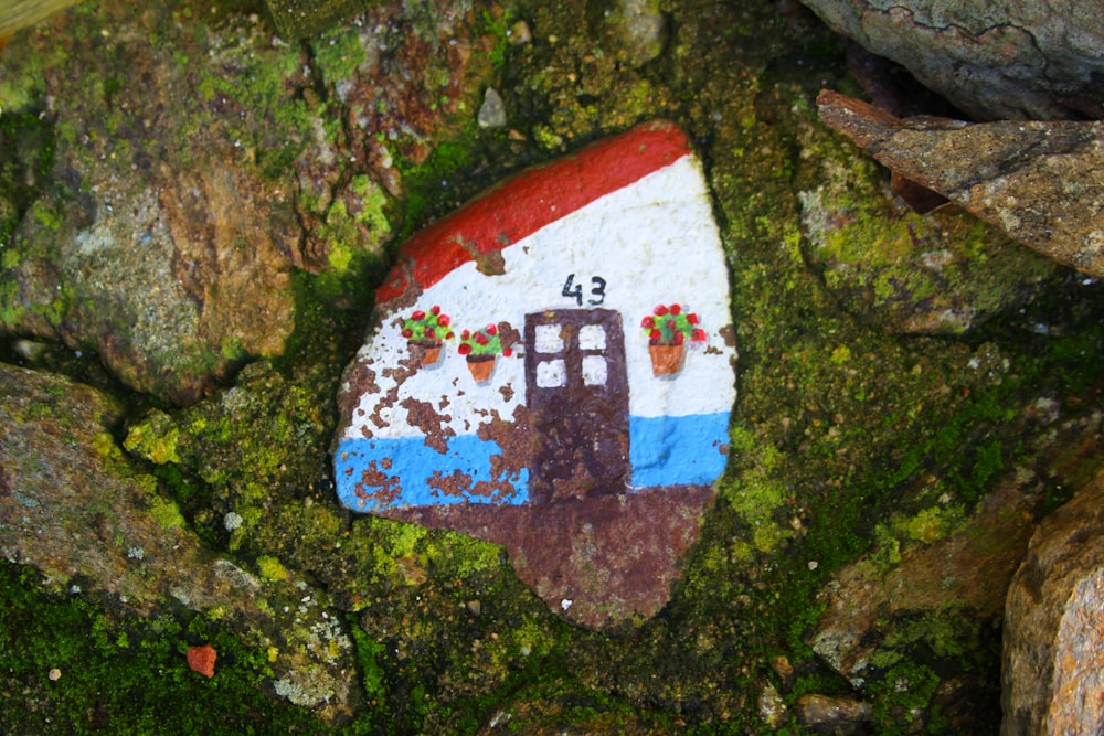 a painted rock with a house on it