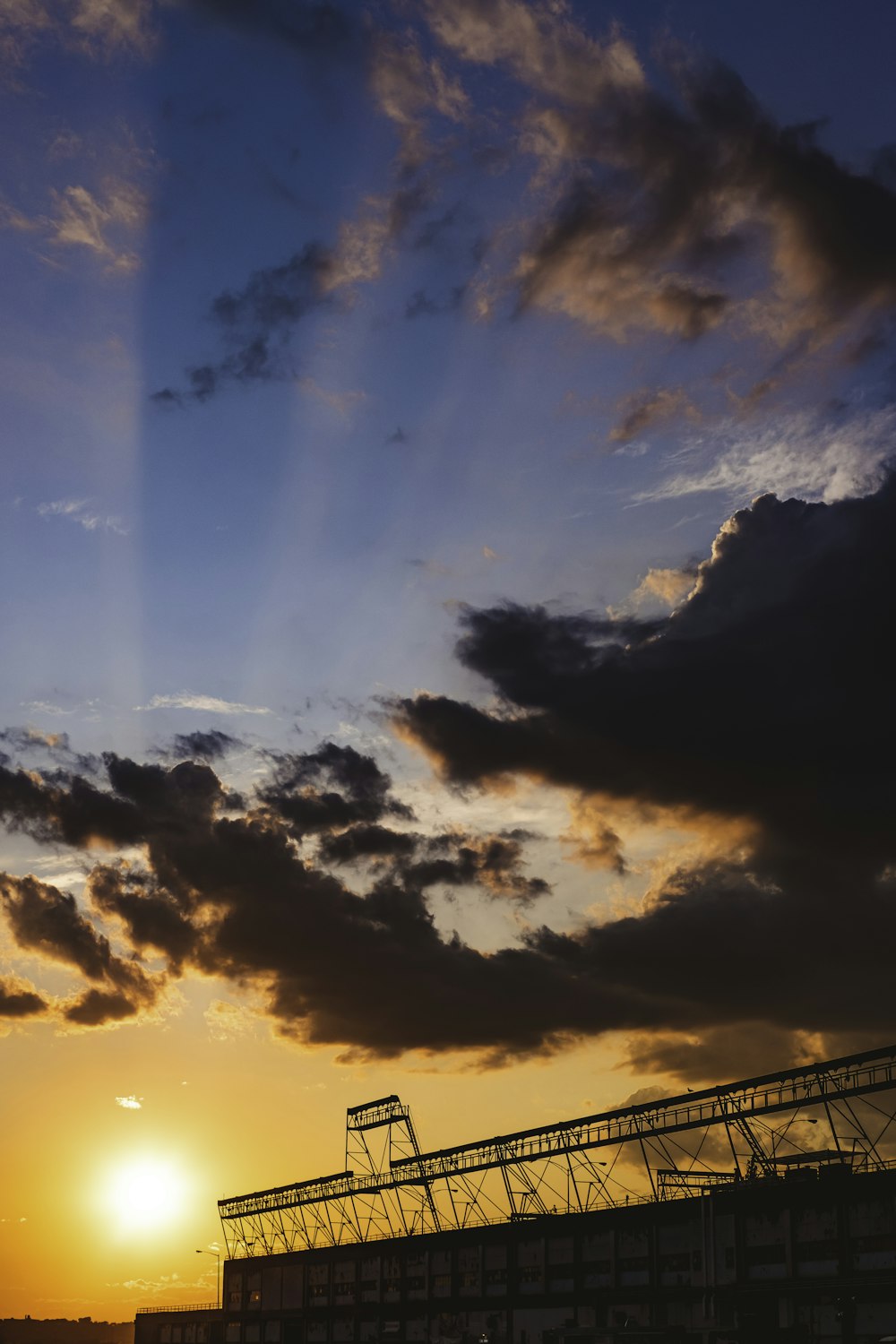 the sun is setting behind a large structure