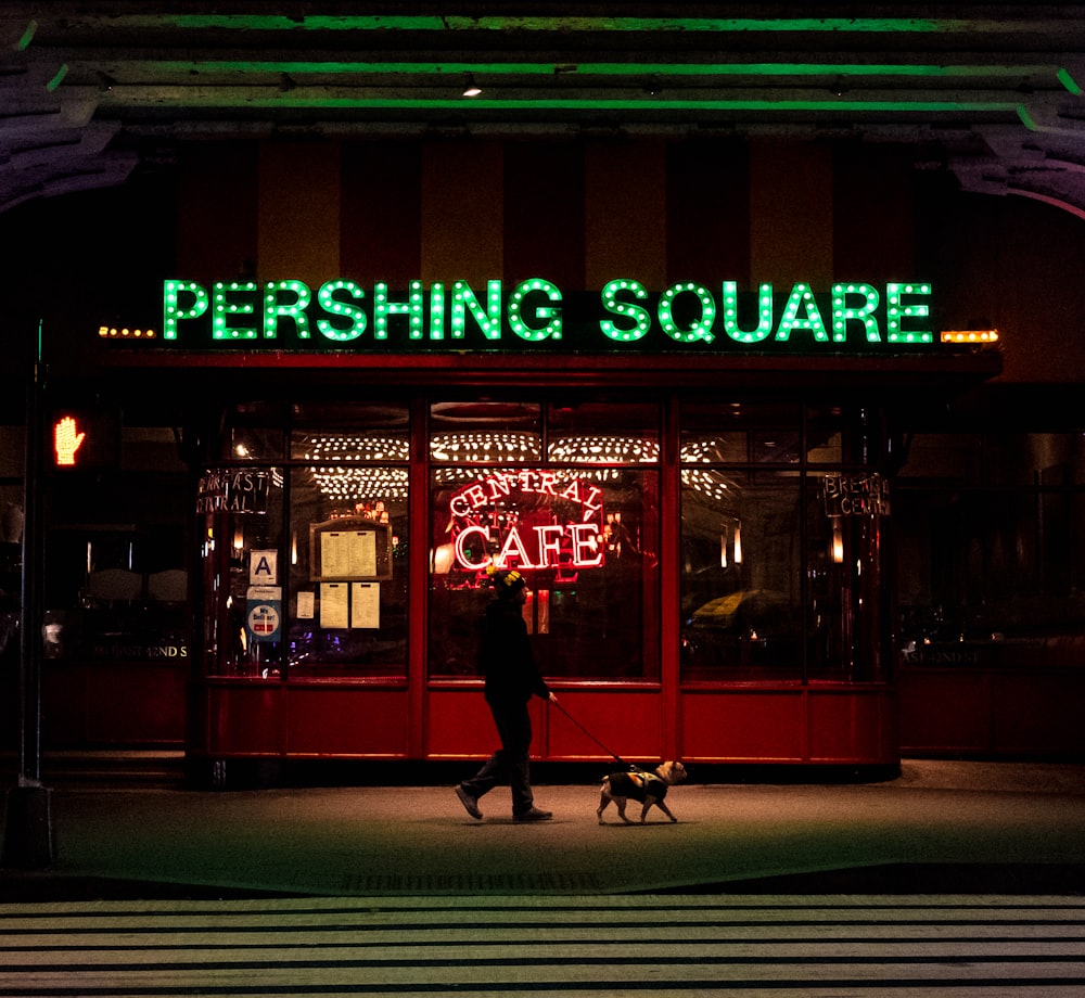 a person walking a dog in front of a building