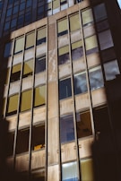 Exterior shot of a building facade featuring a combination of aluminium and UPVC windows reflecting the sky.
