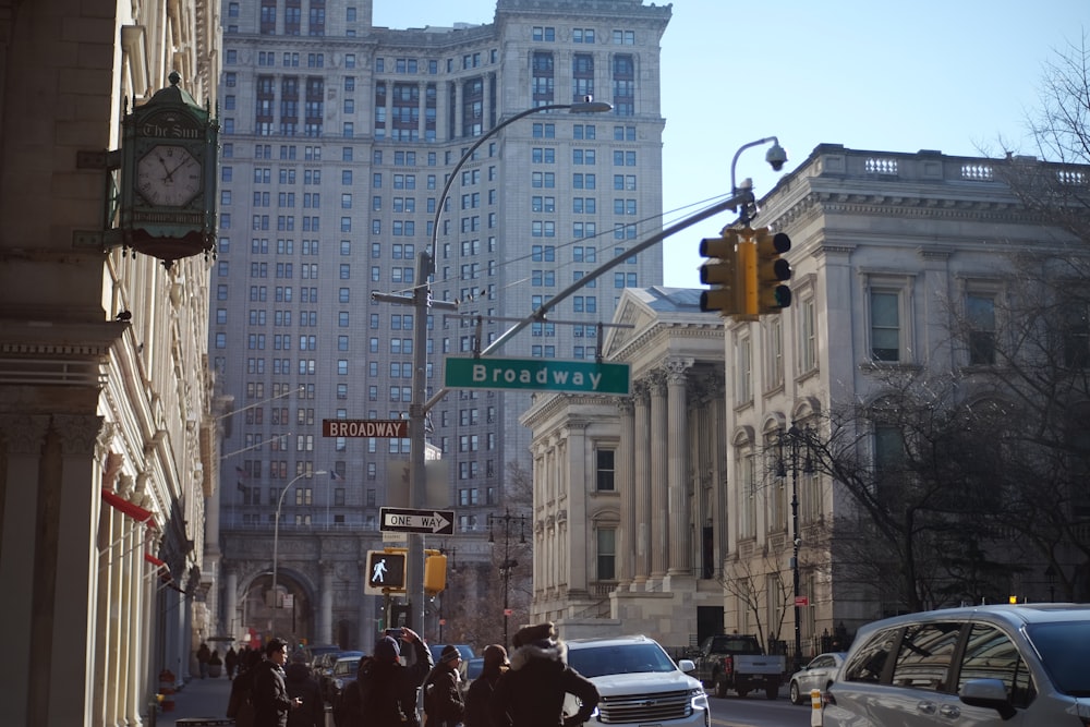 a group of people walking down a street next to tall buildings