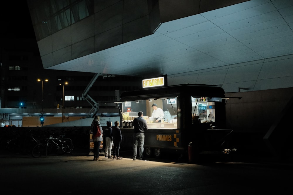 a group of people standing around a food truck