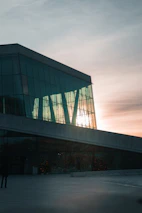 Finished commercial building with glass facade reflecting the sunset.