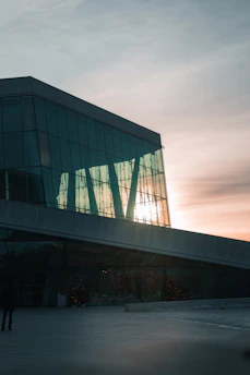 Finished commercial building with glass facade reflecting the sunset.