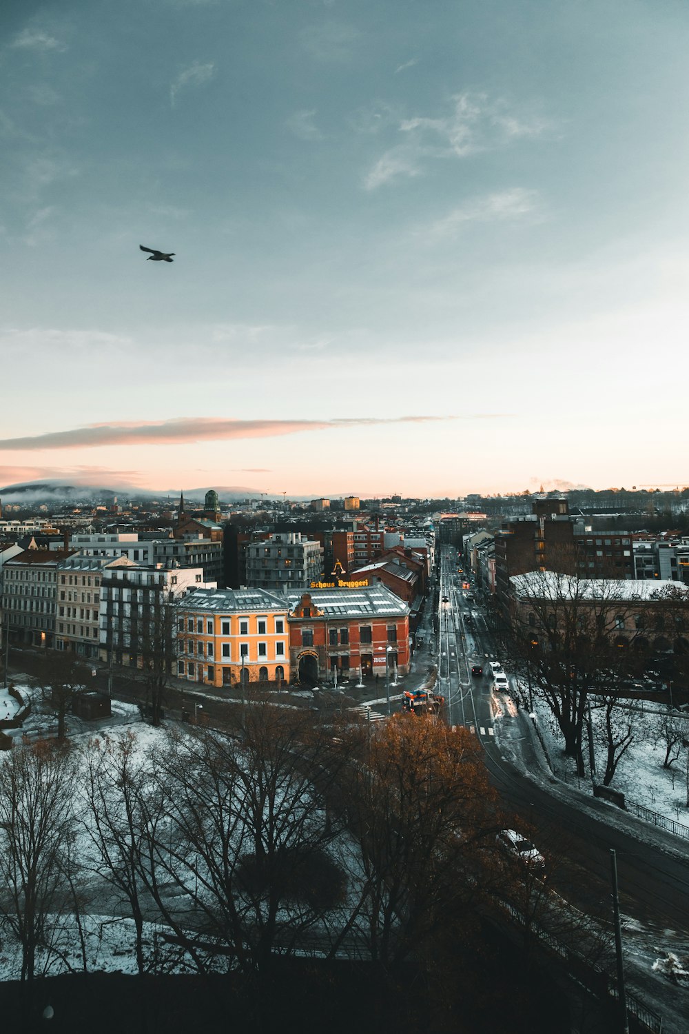 an airplane is flying over a city in the snow