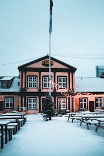A vintage-style brewery storefront on Valtakatu street in Kemi, with snow gently falling around.