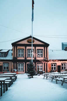 A vintage-style brewery storefront on Valtakatu street in Kemi, with snow gently falling around.