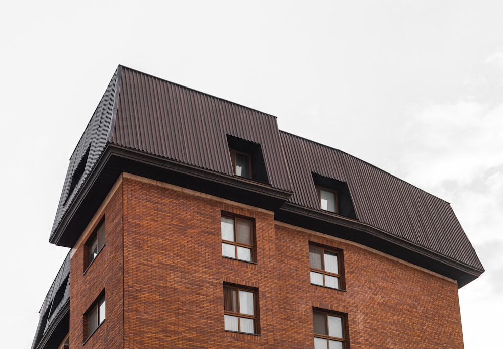 a tall brick building with a black roof