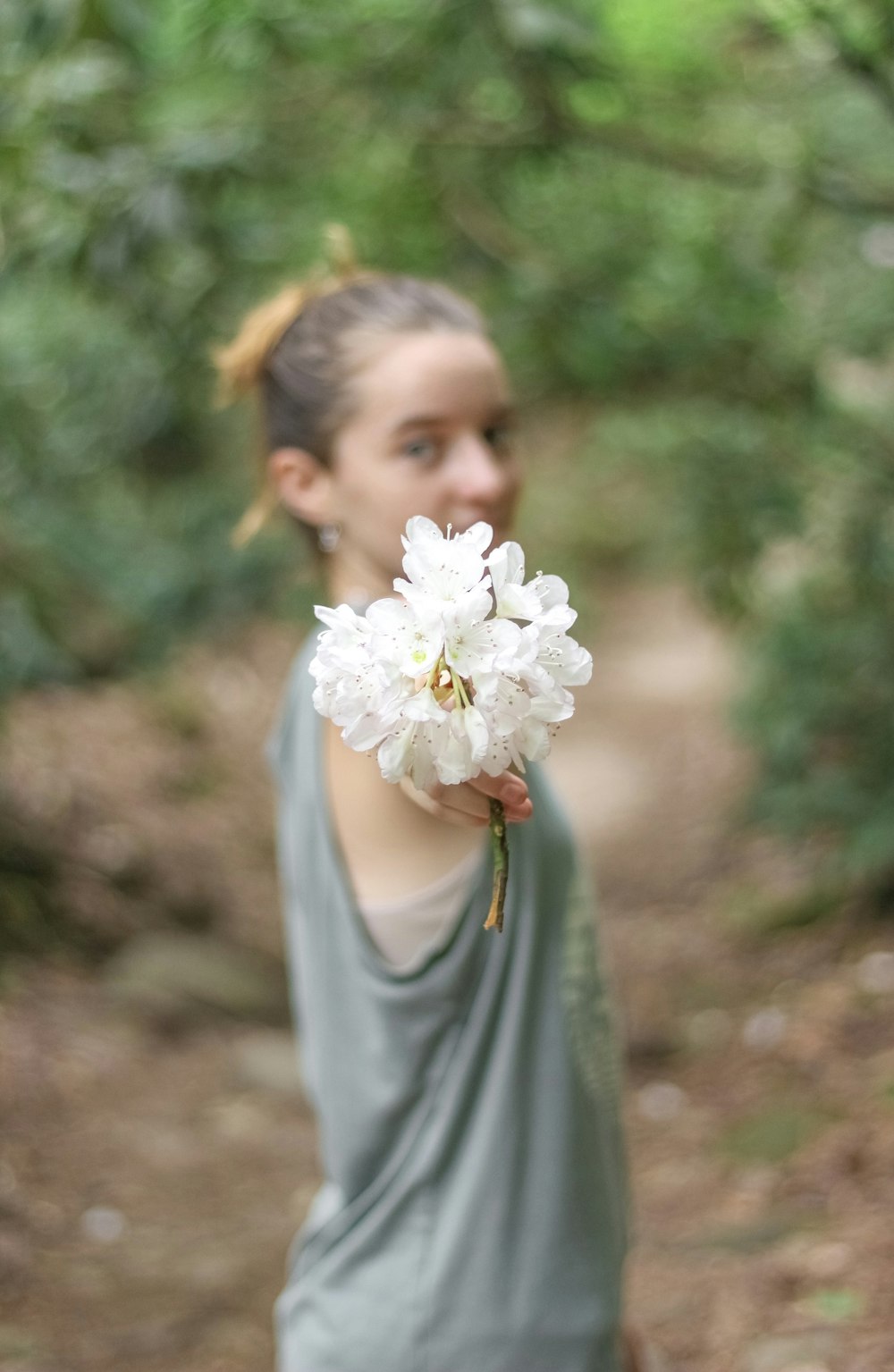 a woman holding a white flower in her hand