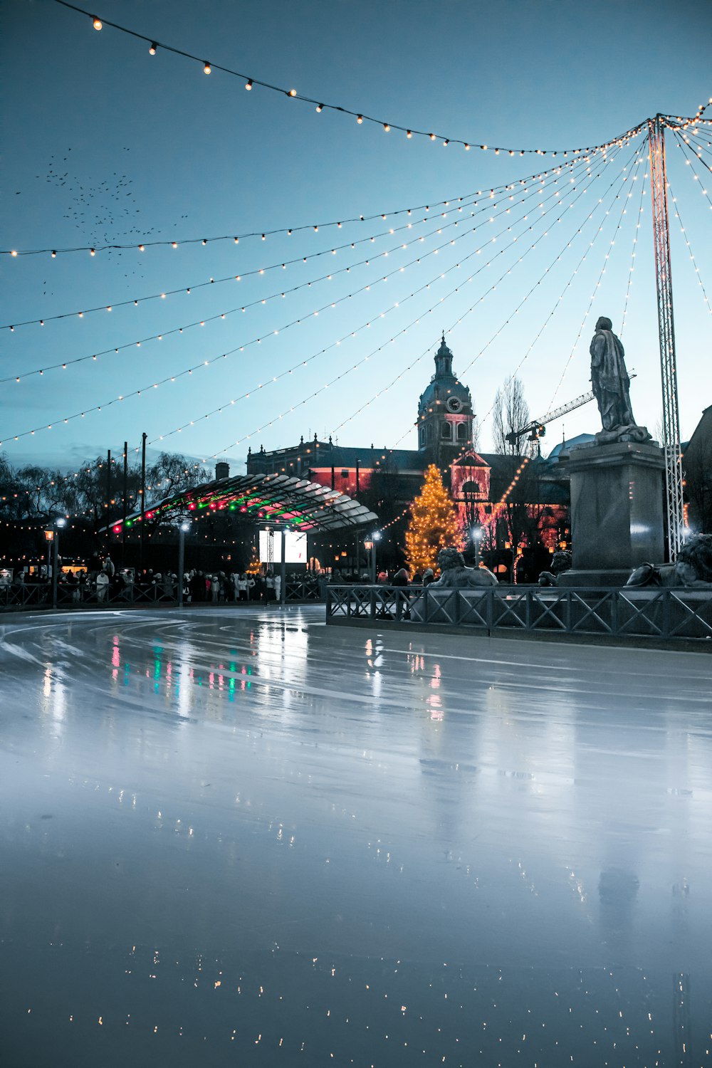 a skating rink with lights and buildings in the background