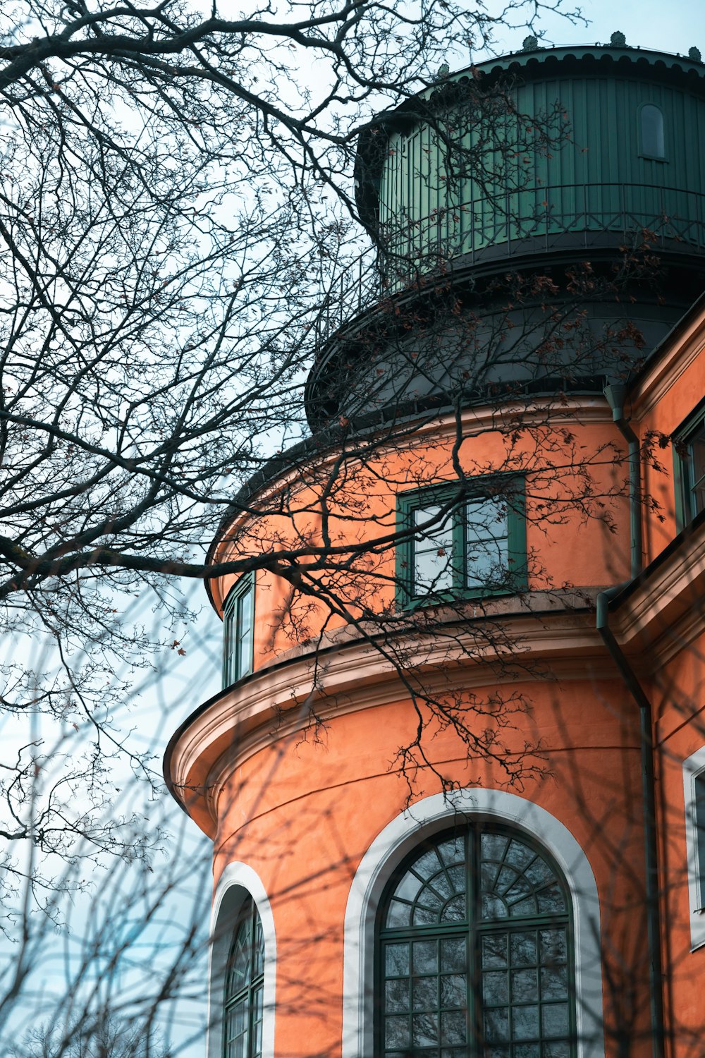 a large orange building with a clock on it's side