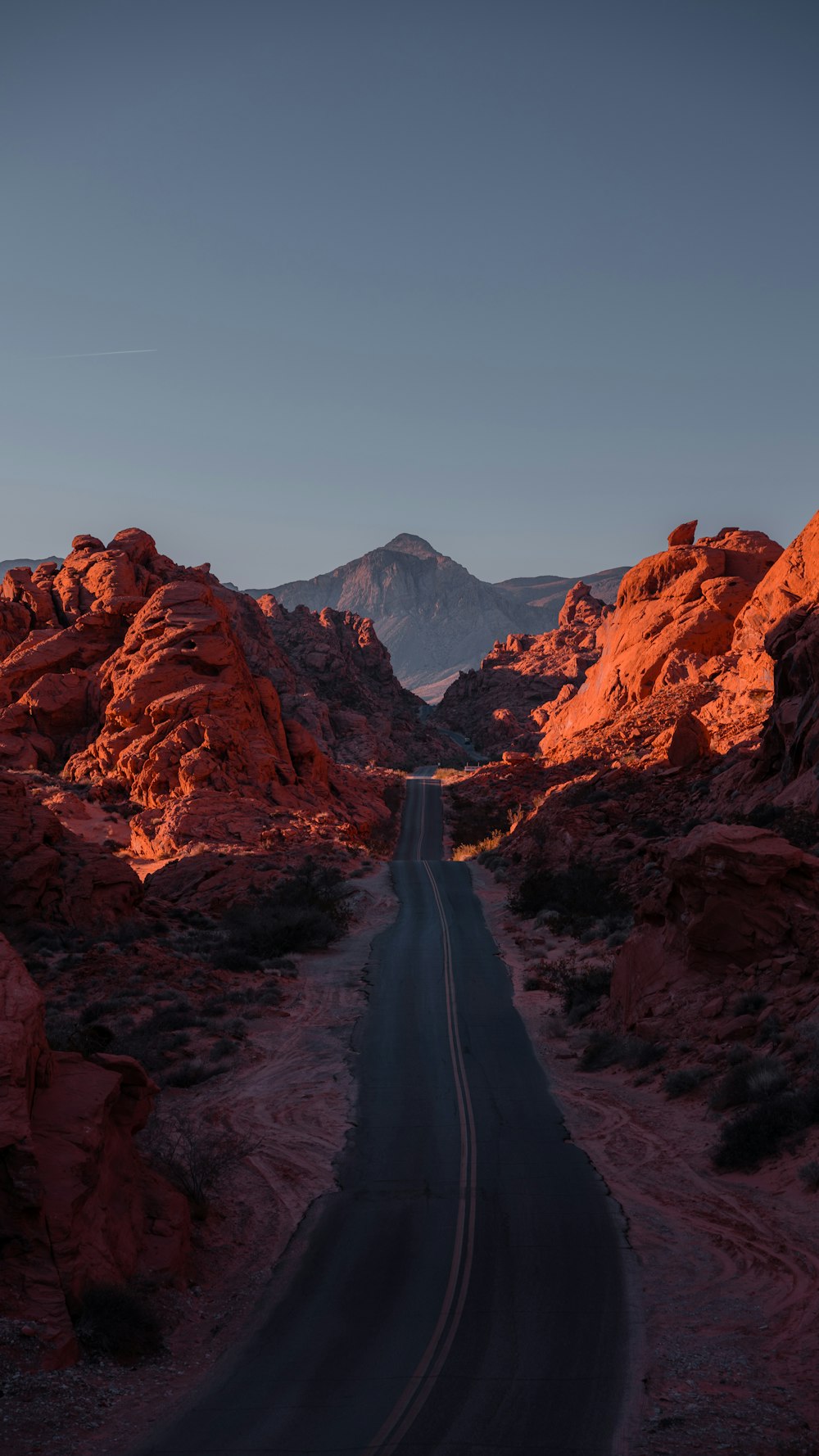 Eine Straße mitten in einer Wüste mit Bergen im Hintergrund