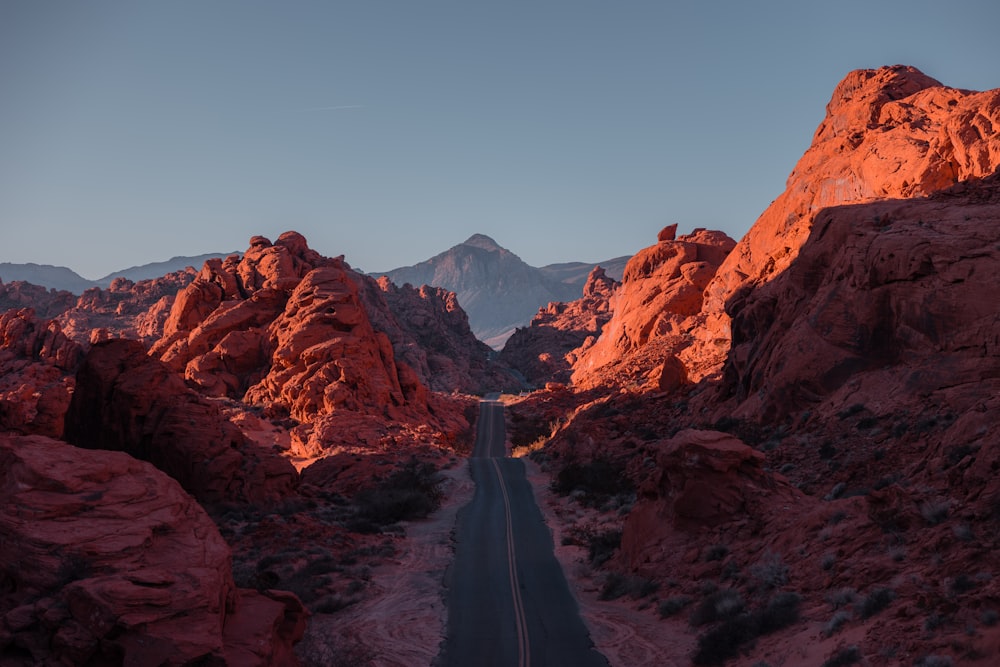 a road in the middle of a desert with mountains in the background