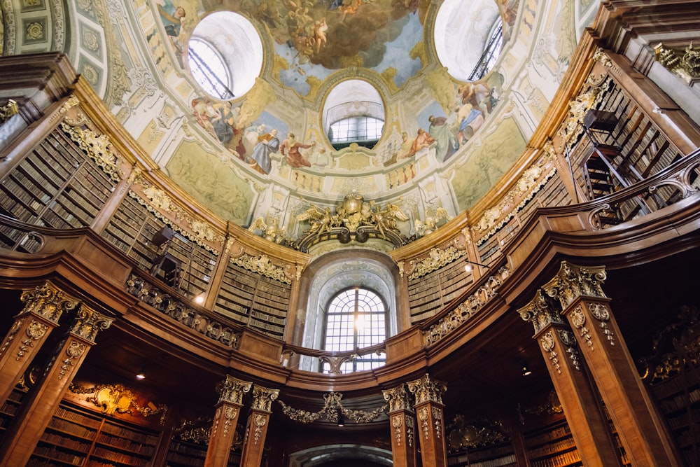 the ceiling of a library with a painting on the ceiling