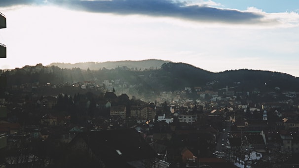 A serene landscape photo showing a quiet regional town nestled among hills.