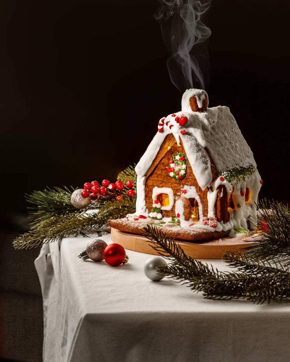 a gingerbread house is on a table with decorations