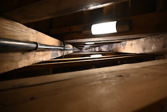 Wide angle view of a crawlspace with new moisture control systems and clean, sealed surfaces.