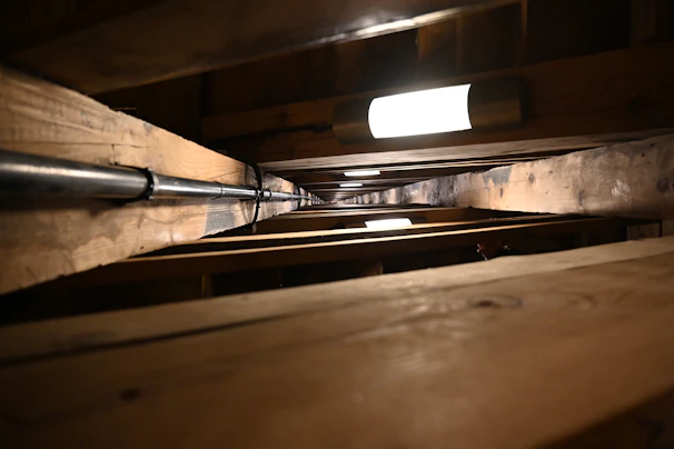 Wide angle view of a crawlspace with new moisture control systems and clean, sealed surfaces.