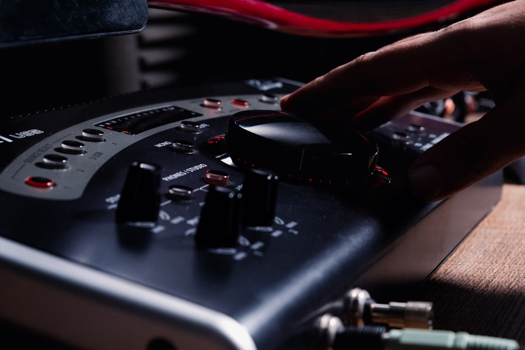 a hand is pressing buttons on a control panel, audio production live