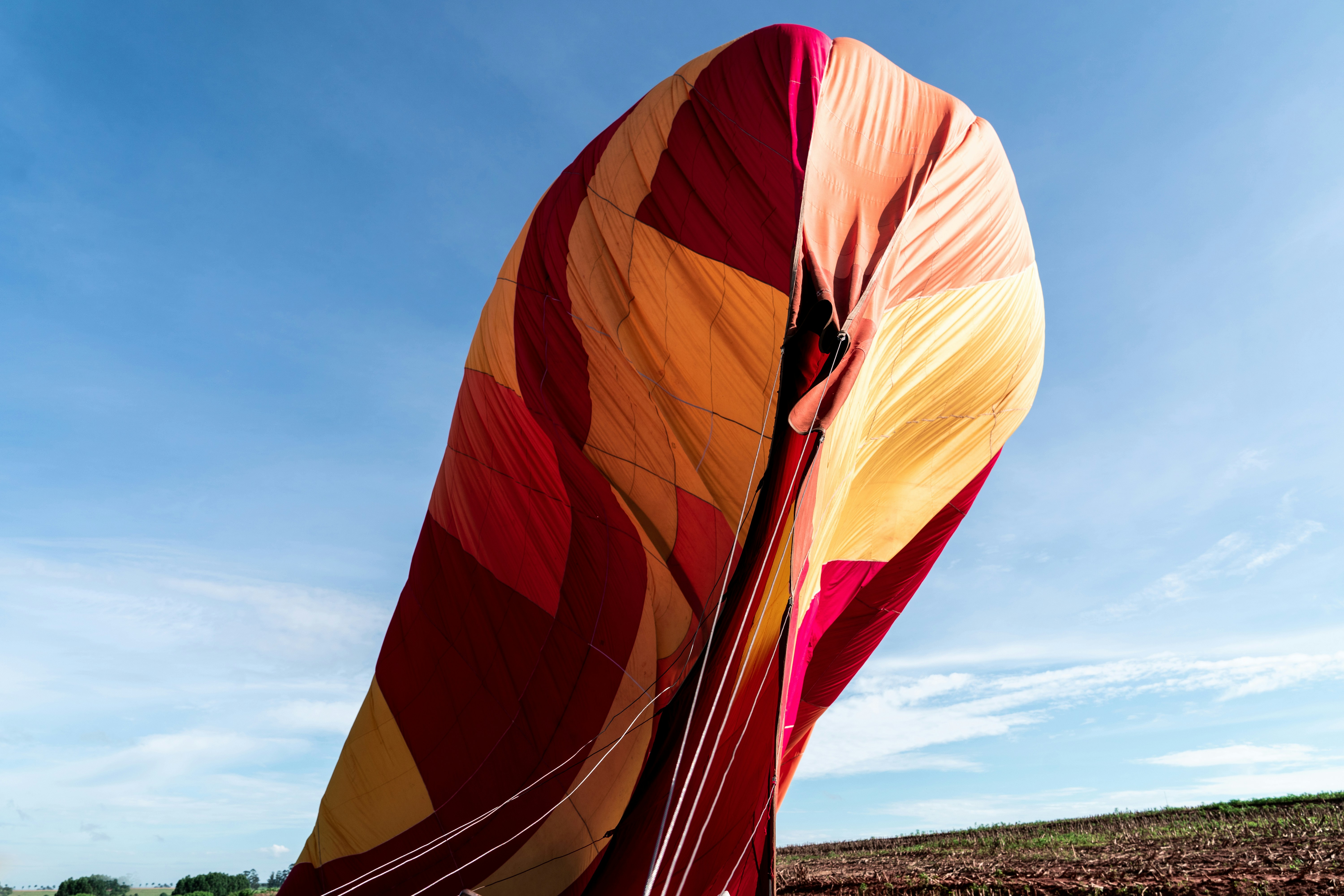 uma grande pipa vermelha e amarela com um fundo do céu