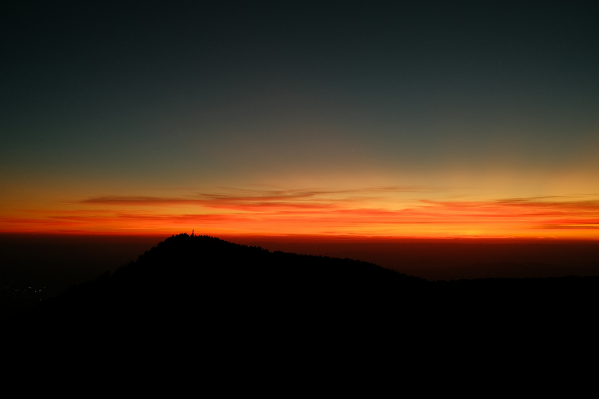 the sun is setting over a mountain top