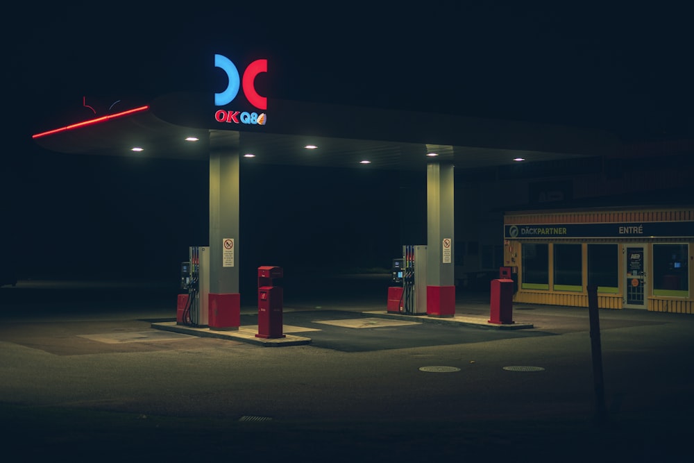 a gas station at night with a neon sign