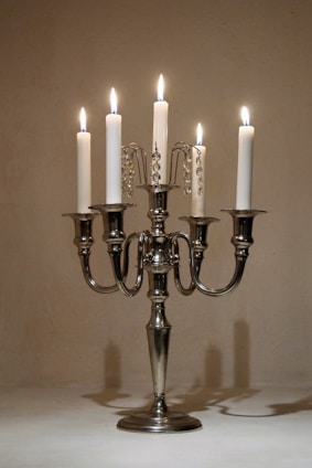 a silver candelabra with five lit candles