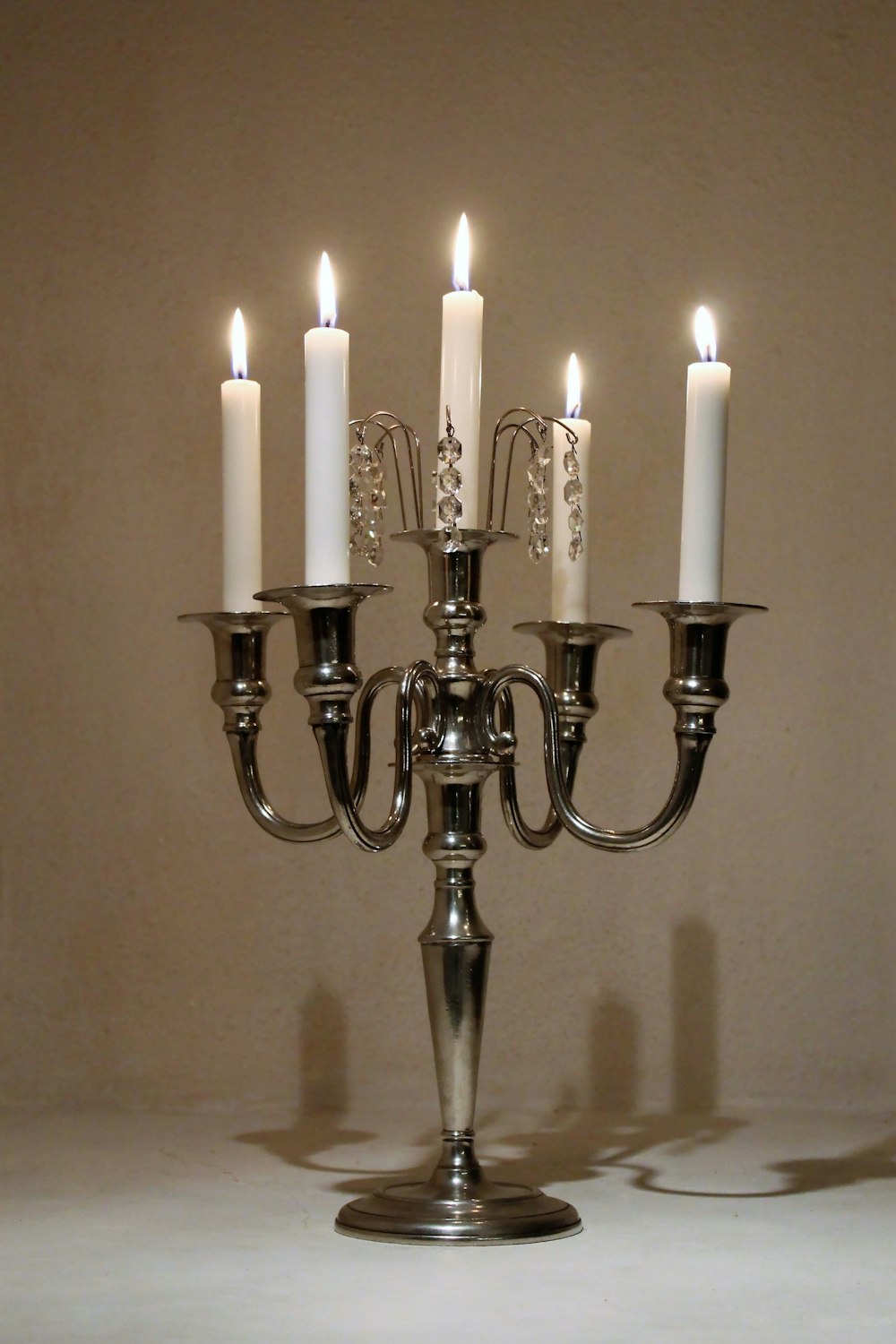 a silver candelabra with five lit candles