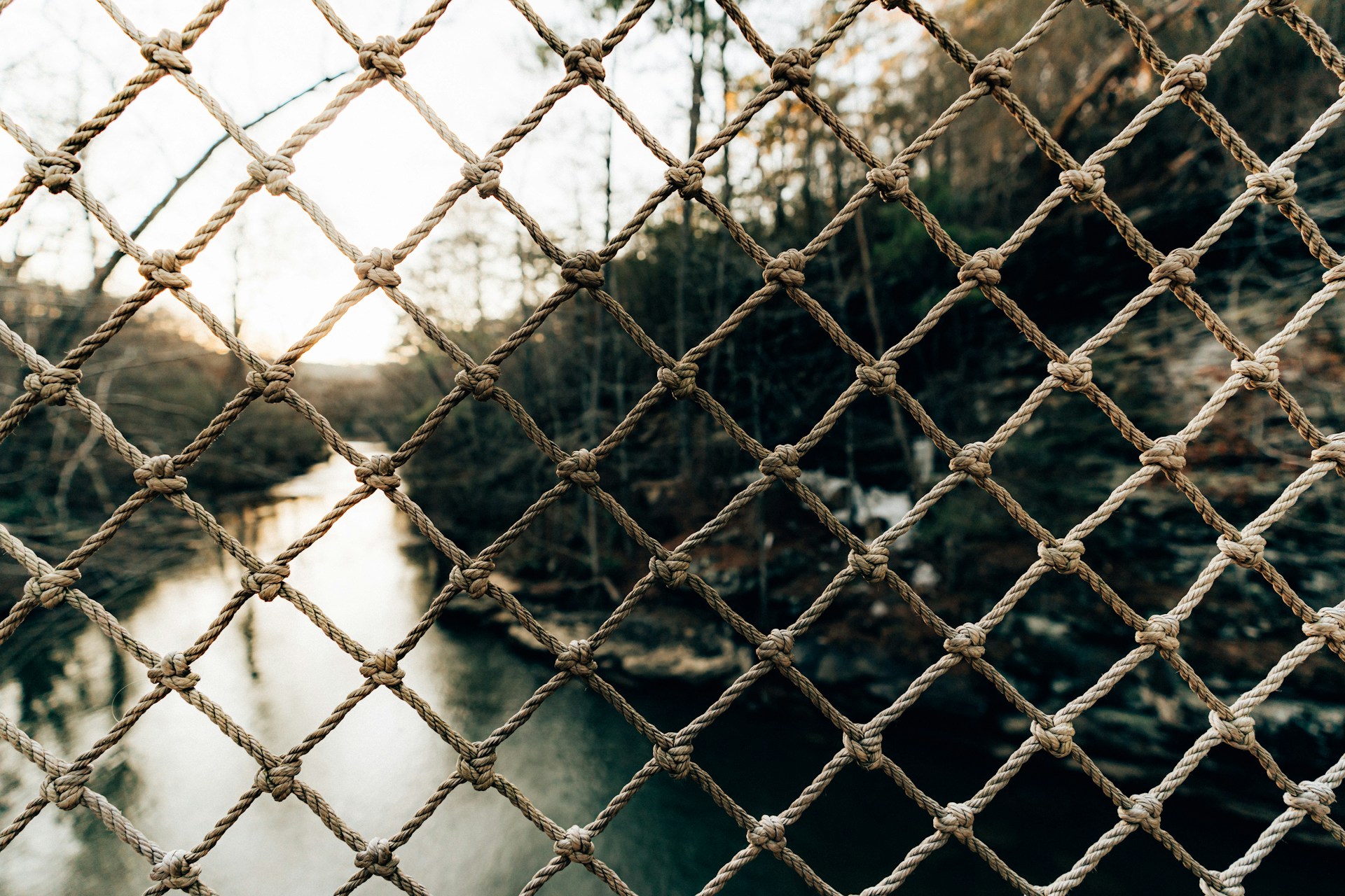 a chain link fence with a river in the background