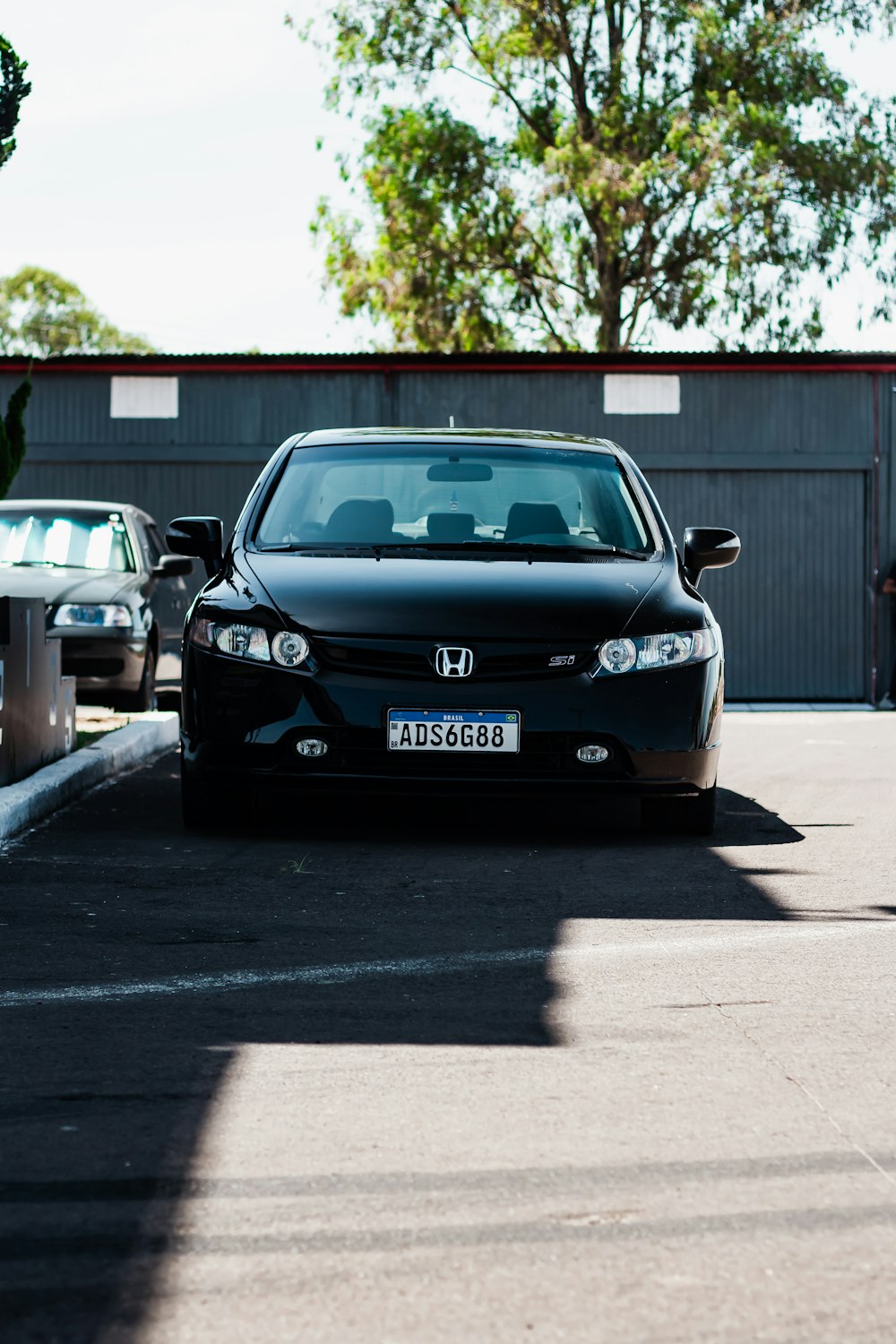a black car parked in a parking lot next to a parking meter