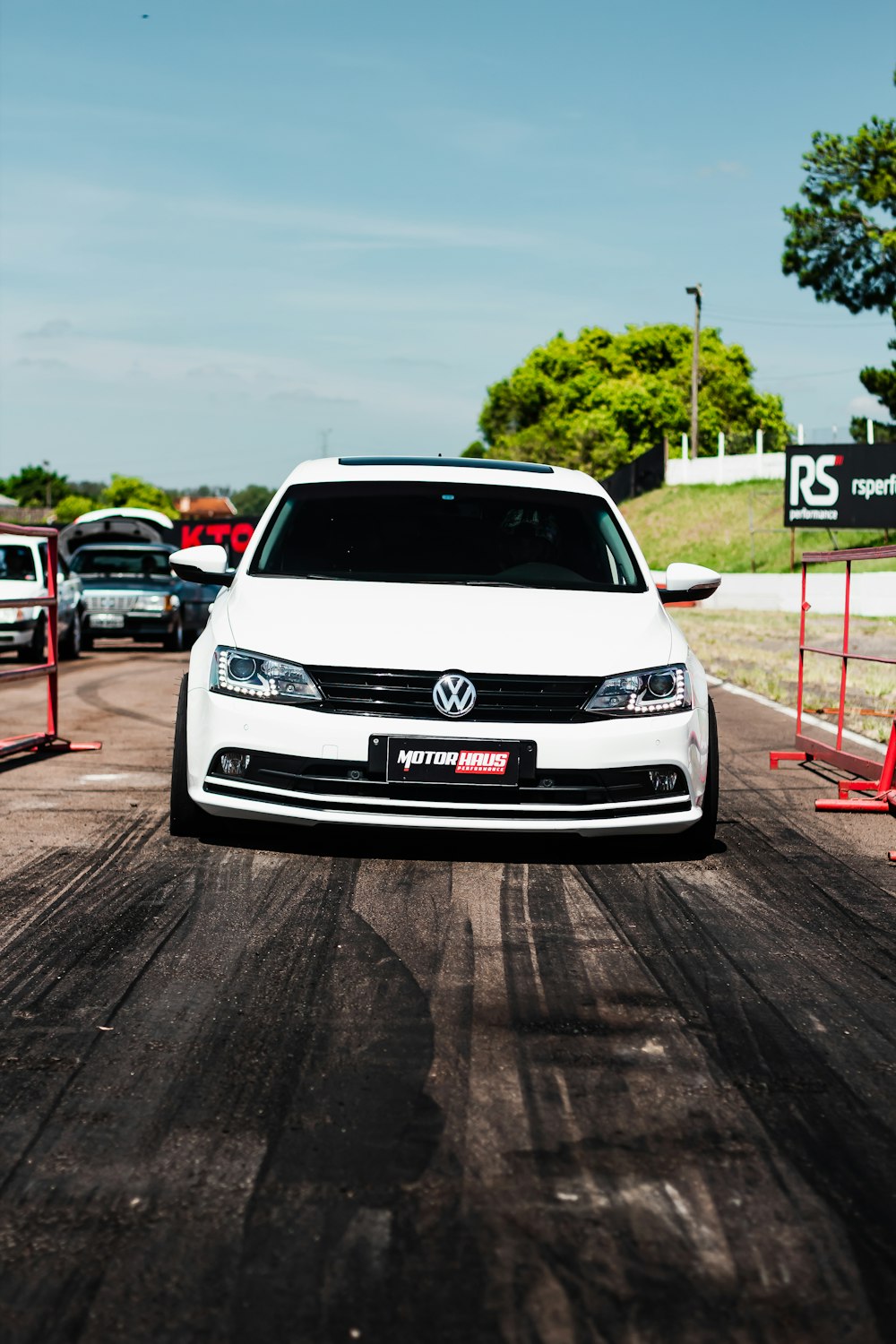 a white car driving down a race track