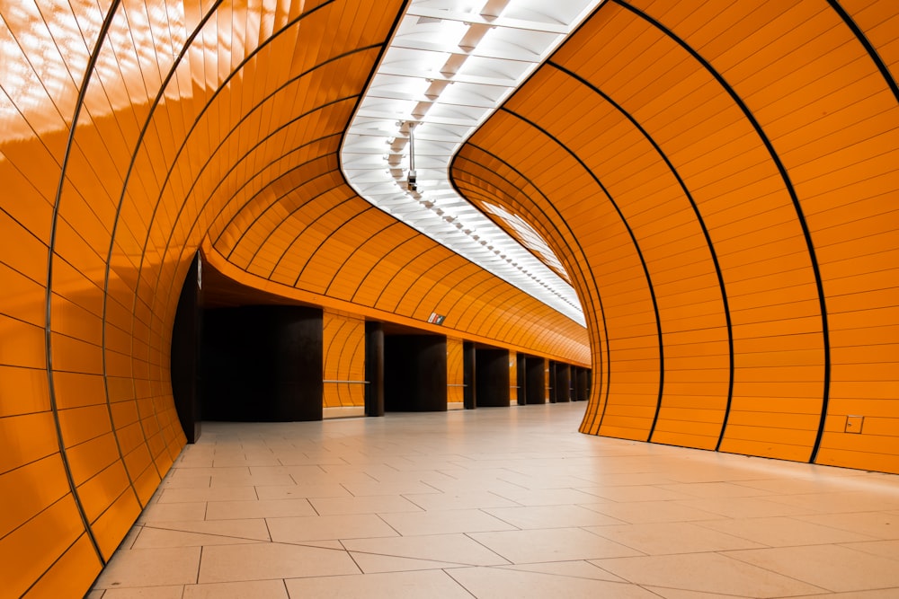 a long hallway with orange walls and a white floor
