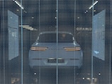 A white car displayed behind a glass panel covered in a matrix of small, bright LED lights creating a futuristic ambiance. The car's rear lights are distinctly visible, surrounded by a dark background that emphasizes the glowing pattern.