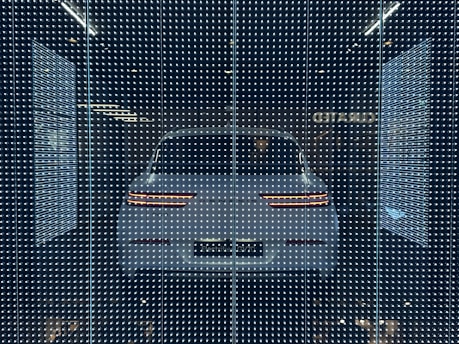 A car door illuminated by vibrant LED lights with a reverse camera view on screen.