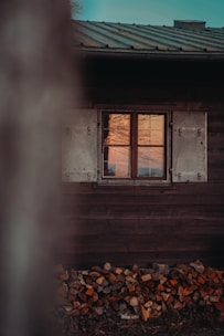 A friendly technician repairing a cozy cabin's wooden door at sunset.