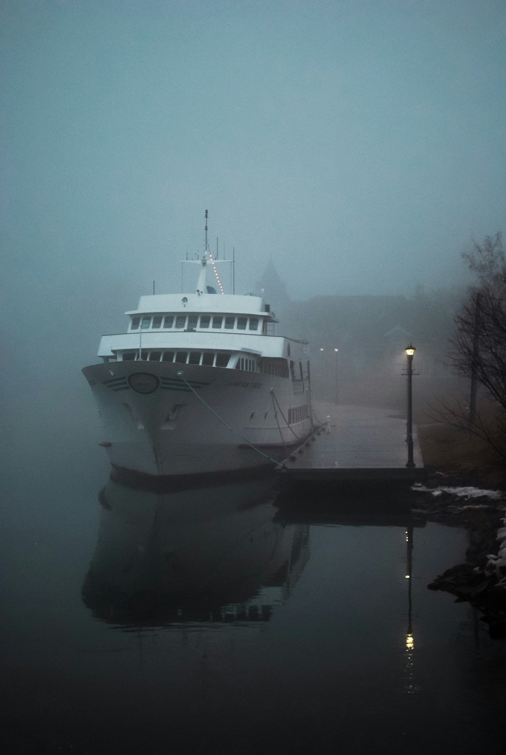 a large white boat in the water on a foggy day