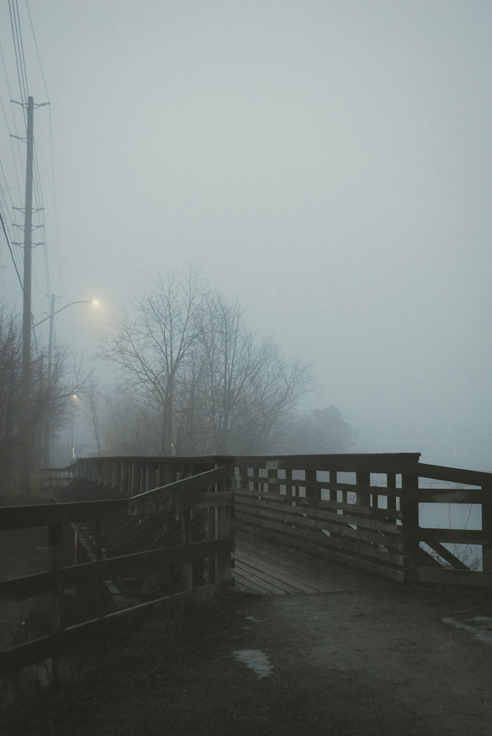 a foggy day on a bridge over a river