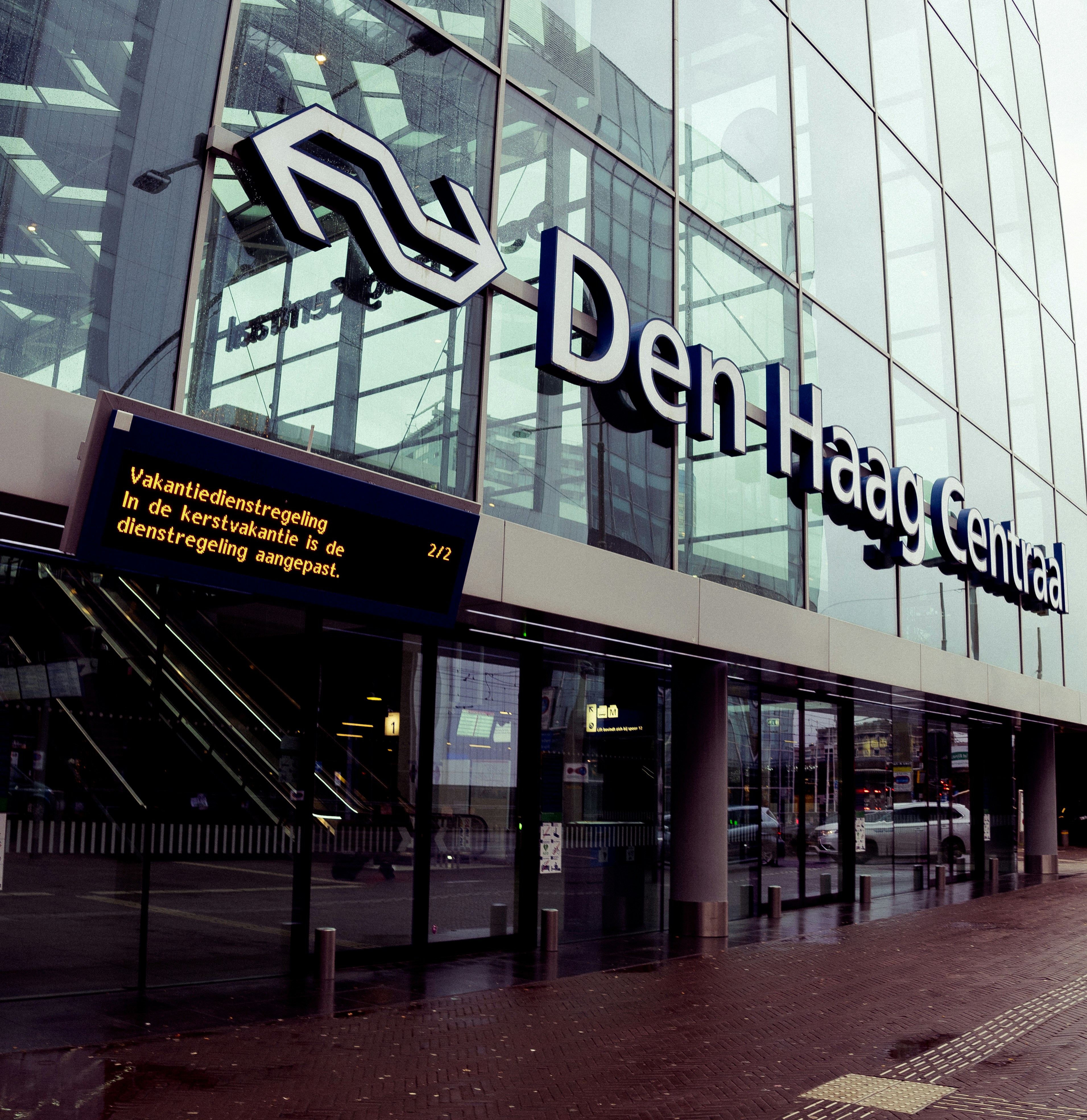 a large glass building with a sign on the side of it