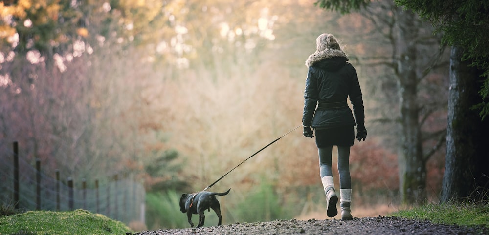 a woman walking her dog in the park