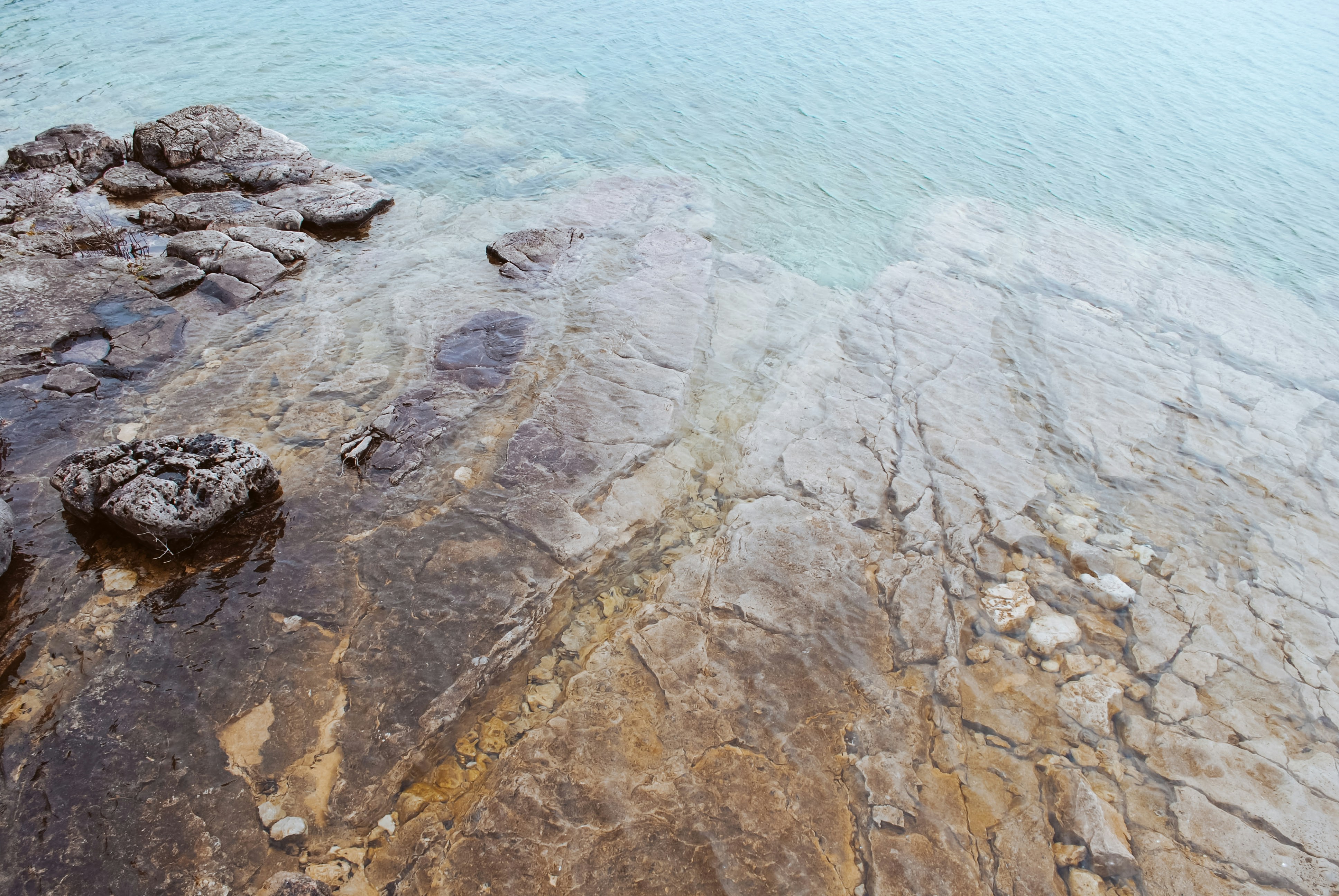 a large body of water sitting next to a rocky shore