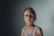 Close-up of a professional woman with glasses, looking thoughtful and approachable.