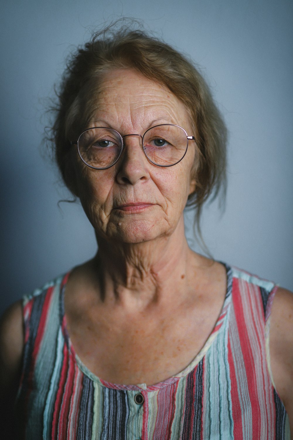 an older woman with glasses looking at the camera