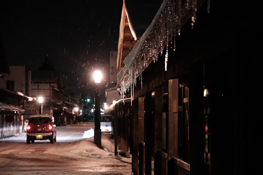 a car driving down a snowy street at night