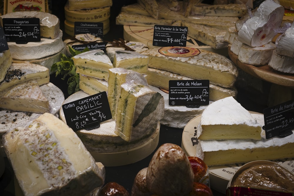 a variety of cheeses are displayed in a display case