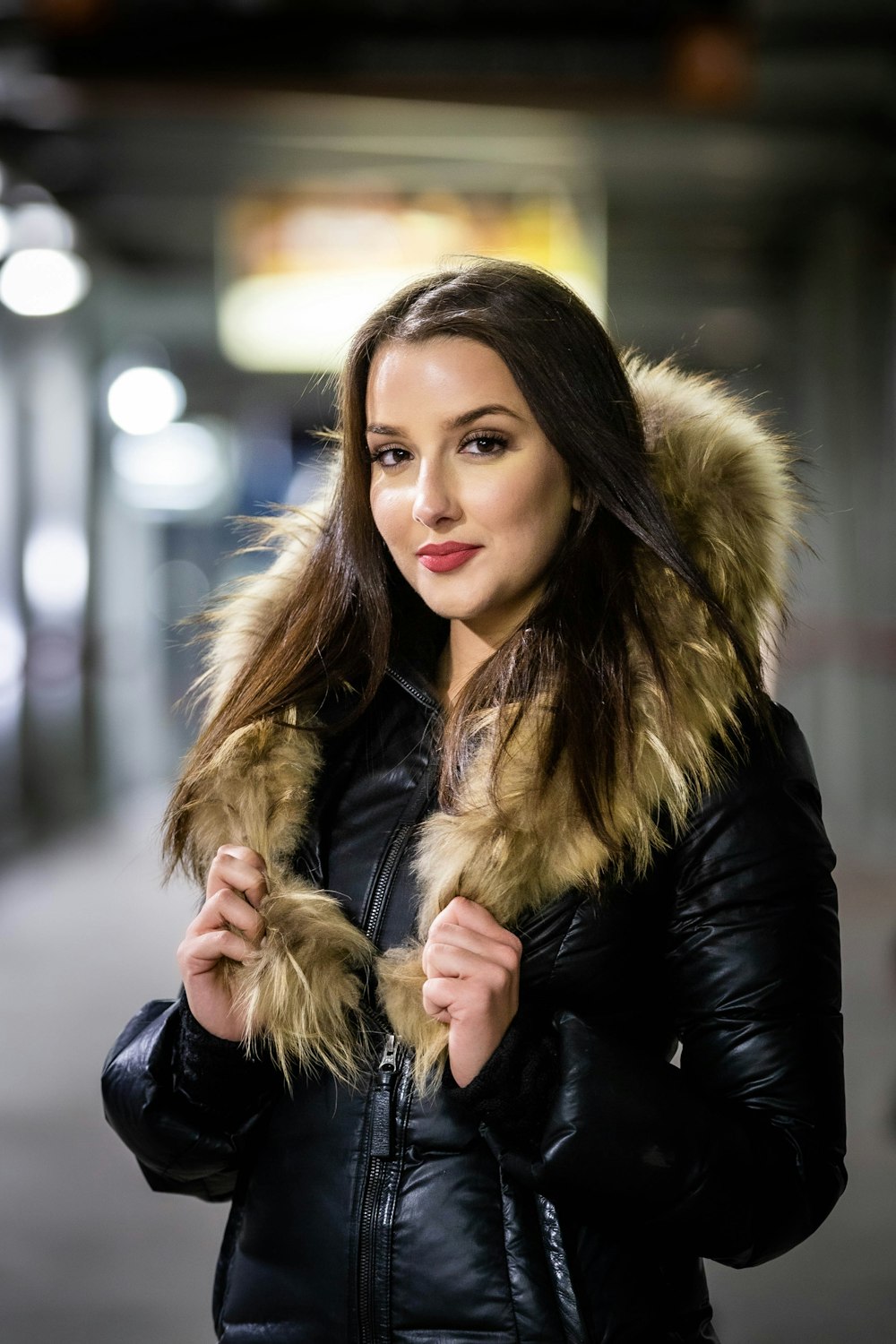 a woman in a black jacket with a fur hood