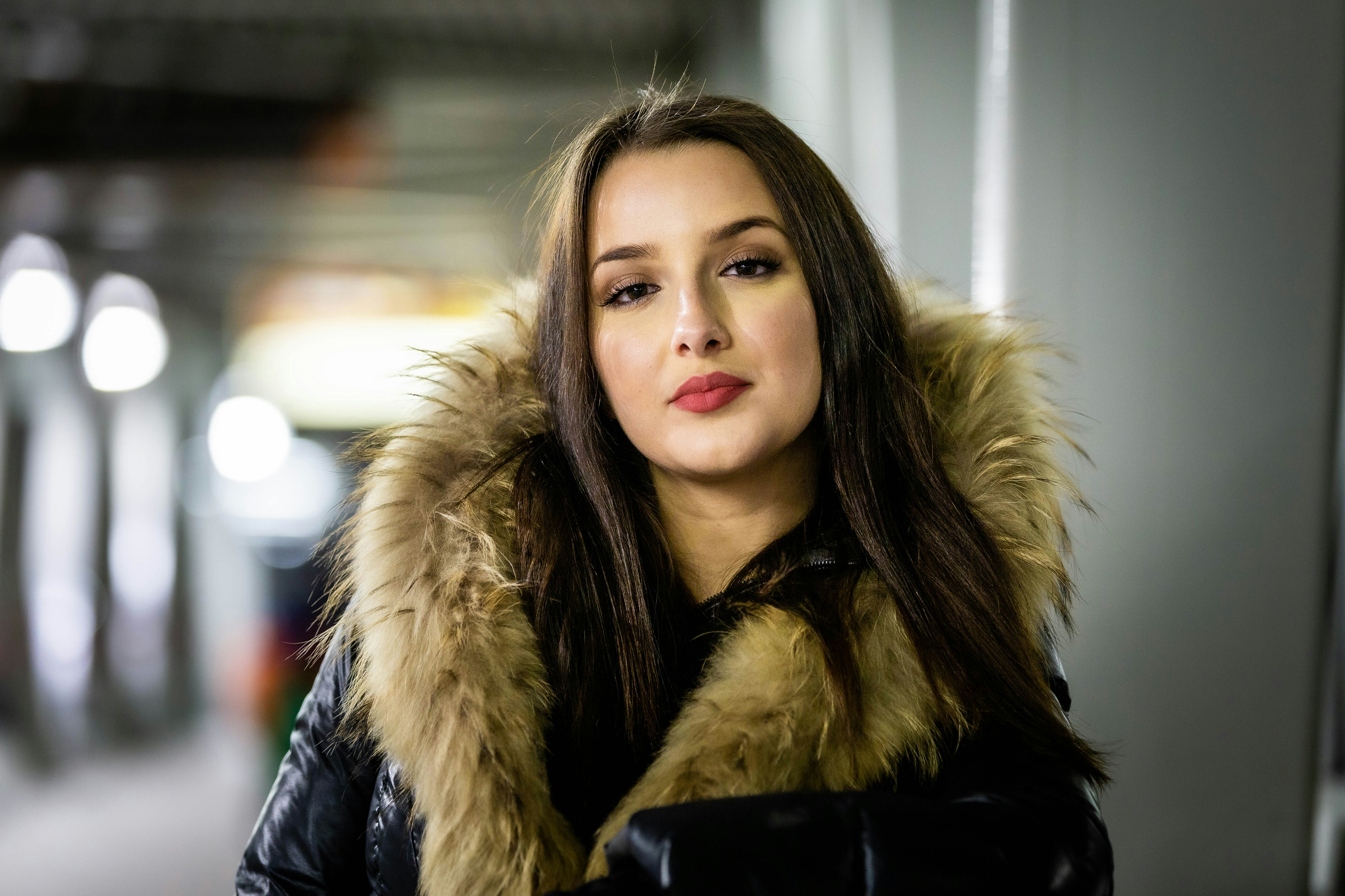 a woman in a black jacket with a fur collar