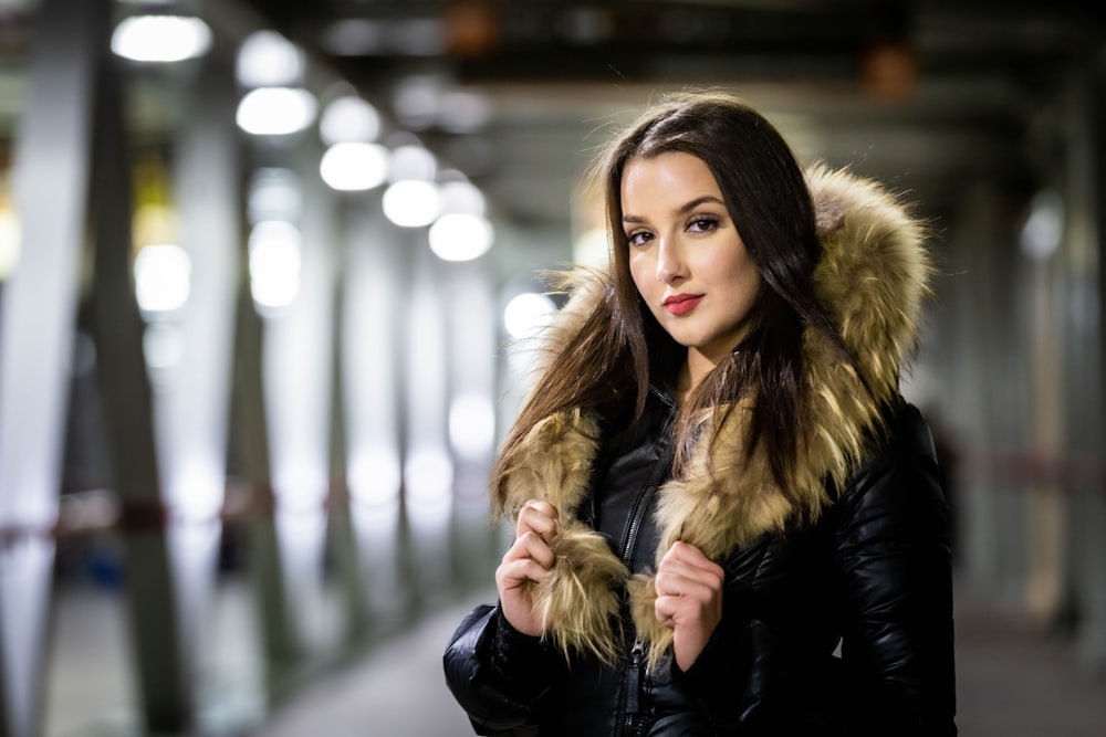 a woman in a black jacket with a fur collar